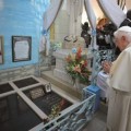Pope Benedict XVI prays during a service at Notre Dame cathedral in Cotonou, Benin Friday, Nov. 18, 2011 on the tomb of Mons. Isidore de Souza