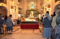 Suore e devoti davanto all'urna di don Bosco