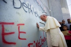 Papa Francesco in preghiera davanti al muro di separazione israeliano