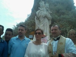 Omagio floreale alla statua della Madonna. In primo piano da dex il parroco don Giovanni Mammino e il vice sindaco di Acicastello Ezia Carbone