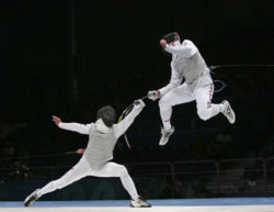 U.S. fencer Jonathan Tiomkin soars above Russian opponent Renal Ganeev in the bronze-medal bout of the men's team foil competition at the Athens Olympic Games. Russia went on to win, 45-38.