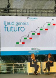 Lunedì 18 Settembre, presso i locali di Radicepura, ha avuto luogo l'evento "Il Sud Genera futuro". Appuntamento annuale organizzato dal Corriere della Sera si è delineato come un interessante storytelling tra voci istituzionali e la concreta realtà di piccole, medie e grandi imprese che vivono il territorio. La convention è stata moderata da Massimo Fracaro, Responsabile editoriale L’Economia del Corriere della Sera e da Nicola Saldutti, Caporedattore Economia, anch'egli del Corriere della Sera.  La location, il suggestivo giardino botanico alle pendici dell'Etna, non è sicuramente un  caso. Quale oasi di biodiversità migliore per poter parlare della biodiversità del Made in Italy?  Il Sud genera Futuro/ L'intervento del Ministro Musumeci Il primo a prendere parola, in un interessante dibattito con Nicola Saldutti è stato il Ministro per la Protezione Civile e Le Politiche del Mare: Nello Musumeci. N.S: "Vorrei focalizzare la Sua attenzione sul sapere dei territori, a partire dal nome di questa suggestiva location, che la legano al territorio mediante delle salde radici. Ma Lei, è il Ministro delle Politiche del Mare, che nonostante a livello globale sia un piccolo mare, comporta il 20% dell'economia italiana". Cosa può dirmi a riguardo?  N.M: Nonostante si tratti del 1% della superficie terrestre, il Mar Mediterraneo è luogo di scambi straordinario. Ma da un punto di vista geopolitico, Siamo molto vulnerabili. Questo perché questo mare è percorso tra due stretti, assai importanti. Da un parte lo stretto di Gibilterra e dall'altro il canale di Suez. L'Italia, pur essendo una penisola quasi del tutto circondata dal mare, non  ha ancora una piena cultura marittima e spesso più che essere protagonista appare come spettatrice." N.S" Non le sembra un paradosso?" N.M: "Sicuramente lo è! Ed è così perché non abbiamo saputo far coesistere, mediante un confronto, le filiere. Da sempre l'Italia ha percepito l'assenza di una cultura marittima scegliendo maggiormente una cultura terragna. Questo perché l'economia italiana è sempre stata trainata dal Nord Italia e non dal Sud. Ad oggi, il mare è una priorità tra gli obiettivi italiani. Il mare, infatti, ha determinato una maggior crescita nella sua economia fra le regioni del Sud rispetto alle regioni centrali e/o del Nord. Si sta formando infatti, qualità di impresa e si è compreso come fare del mare un motore di crescita. Ecco perché il mio ruolo di Ministro"  Il Sud genera Futuro/ Quale è il ruolo delle nuove generazioni?  N.M" Azzardo a dire che abbiamo dato troppa importanza alla questione meridionale. Alla Sicilia, al Sud Italia, non appartiene più questo stereotipo. Questa considerazione va solo a delegittimare il valore delle imprese del Sud Italia. Serve un'iniezione di ottimismo, convincendo i meridionali che anche Noi possiamo competere con il sistema settentrionale. Bisogna sostenere la nuova generazione di imprenditori del Sud, perché fare impresa in Sicilia è molto più difficile che farla in Lombardia, per una serie di motivazioni ben note. Dunque, chi fa impresa in questo contesto è un eroe. In un mercato sempre più globalizzato la sfida la vince solo chi rischia. Le nuove sfide divanzi a noi impongono la necessità di mettersi in gioco, in un contesto geopolitico non sempre favorevole. Tutto quel che si fa, soprattutto nel settore del MADE IN ITALY si deve costantemente conquistare. Questo permetterebbe al gap tra Nord e Sud di appiattirsi totalmente. Trovare un siciliano ottimista nel settore è difficile ma io lo voglio essere. Non voglio alimentare ancora di più la cultura della rassegnazione!" Il Sud genera Futuro/ L'intervento di Giampiero Maioli L'evento, organizzato dal Corriere della Sera con Credit Agricole come main partner, ha infatti visto anche l'intervento di Giampiero Maioli, Responsabile del Credit Agricole in Italia. Classe 1956, nel corso del suo lavoro ha messo a segno una costante crescita di redditività per una banca sempre più aperta, green e sostenibile anche nel contesto del Sud. Fa parte dell'etica di questa Banca internazionale, infatti, comprendere il territorio per poterlo sfruttare nelle sue potenzialità. Maioli, ritiene infatti, sempre più importante il ruolo della sostenibilità. Per fare economia è fondamentale sottolineare questo ruolo. Ed un peso non indifferente è svolto dalle nuove generazioni, sempre pronte a mettersi in gioco, sfidando non solo le leggi di mercato ma anche quelle territoriali.  Il Sud genera Futuro/ Le due tavole rotonde Dopo le importanti premesse, hanno preso parola imprenditrici ed imprenditori siciliani in due tavole rotonde. In un lungo dibattito si sono confrontate personalità eterogenee tra di loro con un comune denominatore: il futuro del Sud Italia. La prima tavola rotonda ha visto la presenza di tre donne importanti come Maria Cristina Busi Ferruzzi, Presidente Sibeg, Giusy Damigella, CFO – Mondial Granit SpA e Elita Schillaci, Docente universitario dell’Università di Catania. Nel corso del dibattito sono intervenuti anche Mario Faro, patrone di casa, responsabile de "Faro Flora e Faro Piante" e Gerardo Diana, Presidente del Consorzio di Tutela Arancia Rossa di Sicilia IGP. Difatti l'obiettivo del meeting era proprio quello di sentire storie tra loro diverse dando loro però la stessa cassa di risonanza..  Parola alle imprenditrici e agli imprenditori La prima a prendere parola è stata M.C. Busi Ferruzzi, figura emblematica in Sicilia dal 1977 per il marchio Coca-Cola, a Catania e Palermo. Tredici anni dopo inaugura a Catania lo stabilimento SICAVI che svolge l’attività di produzione di bottiglie PET. Per lei la Sicilia è stata cambiamento ed accoglienza.  Il secondo a prendere la parola è stato M. Faro, che tramite un excursus familiare, di quasi sessant'anni, ha reso noto alla platea l'importanza, per una realtà come la sua, dell'apertura mentale al cambiamento e al futuro, in Sicilia. Ed in un contesto del genere, la sostenibilità svolge un ruolo importante. Cercare delle soluzioni innovative, anche con materia prima riciclata, è fondamentale. E la continua ricerca verso il salvaguardare il Paese inevitabilmente rende sempre più vicini i rapporti tra le Banche e le imprese.  Gerardo Diana, Presidente del Consorzio di Tutela Arancia Rossa di Sicilia IGP sottolinea sempre più queste capacità aziendale anche dal punto di vista agricolo, che gli permettono di mantenere la sua leadership non solo a livello nazionale ma anche fuori dal contesto europeo.  Le parole degli imprenditori trovano pienamente conferma nella figura di Elita Schillaci, professoressa Ordinaria di Imprenditorialità, che non solo conferma le diverse realtà imprenditoriali ma insieme alle colleghe sottolinea l'onore di essere una Donna in un contesto aziendale, andando contro stereotipi e pregiudizi purtroppo ancora fortemente presenti.   Il Sud genera Futuro/  Vecchie e nuove generazioni a confronto  L'ultima tavola rotonda ha visto protagonisti quattro imprenditori: Giuseppe Condorelli, Amministratore delegato Condorelli, Giorgio Vanadia, Amministratore delegato Ceramiche De Simone, Salvo Salerno, CEO & Chairmanof the Board Reiwa Engine e Nico Torrisi, Amministratore delegato SAC. Realtà diverse ma giovani. Gli imprenditori sono dell'idea che ormai, il futuro di queste nuove realtà imprenditoriali è nelle mani delle nuove generazioni. Una tematica sempre più tangibile e sottolineata più volte nel corso del meeting. E' tutto nelle mani dei giovani. Appartiene a loro il cambiamento. Figlie non solo della crisi economica del 2008, ma anche del cambiamento climatico, in un mondo in via di riscaldamento sempre più veloce e pericoloso. Il focus viene messo su un cambio radicale di paradigma, non esiste più un'ottica settentrionale o meridionale, il tutto dev'essere inteso come senza confini. Ma serve fiducia nelle capacità di queste giovani risorse italiane. Ed il Sud è in grado di generare futuro, a patto che, prima, si creda maggiormente nelle sue potenzialità e in quelle di chi, scommette in se stesso sfidando pregiudizi e stereotipi. 