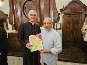 il vescovo Raspanti e padre Panebianco che mostra il suo album