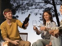 Giovani consumano vino in compagnia